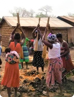 Les femmes pilent l'argile mélangée à de la paille.